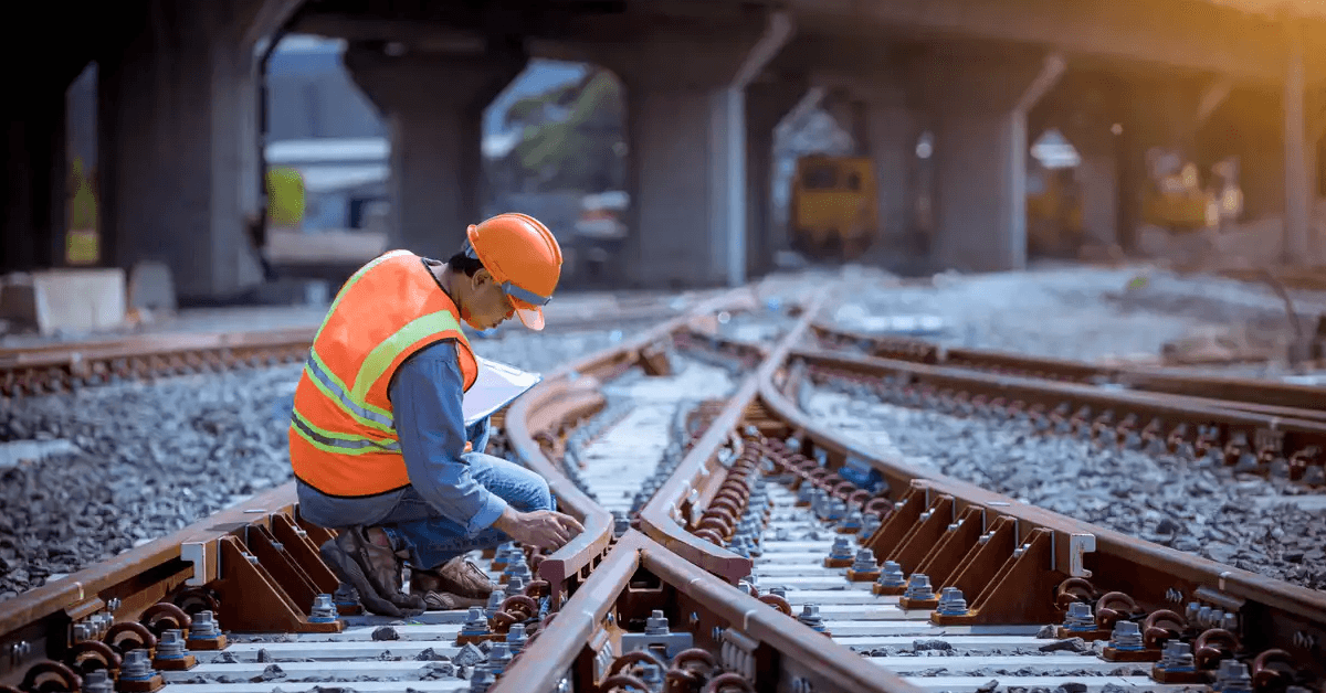 Portrait engineer under inspection and checking construction process railway switch and checking work on railroad station .Engineer wearing safety uniform and safety helmet in work