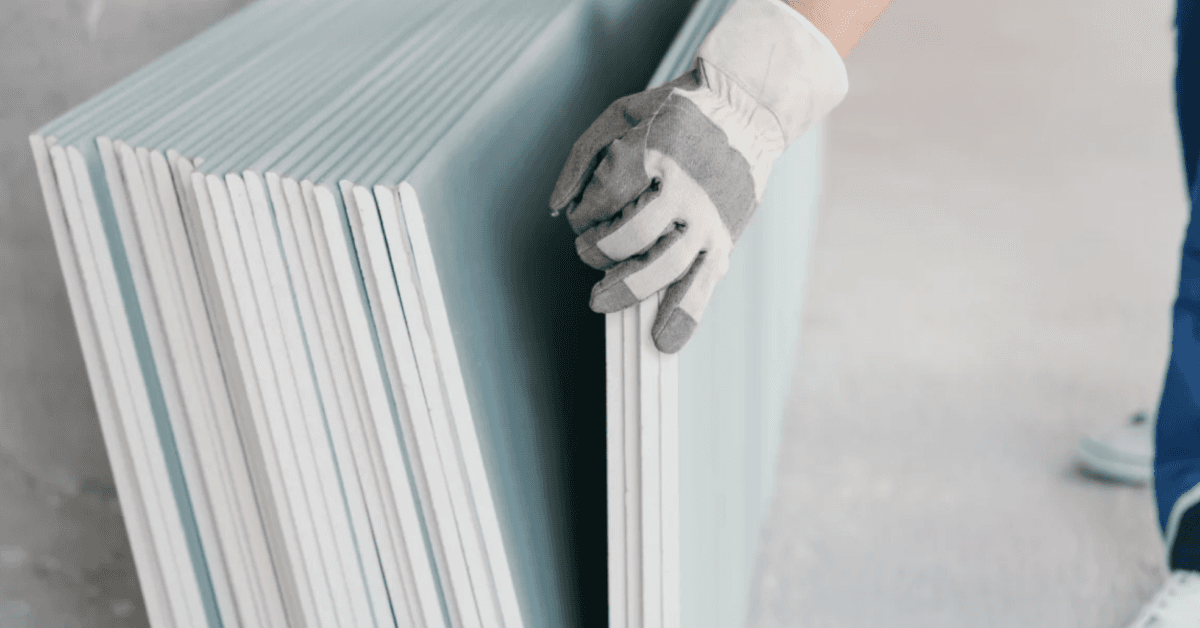 Builder taking a sheet of drywall