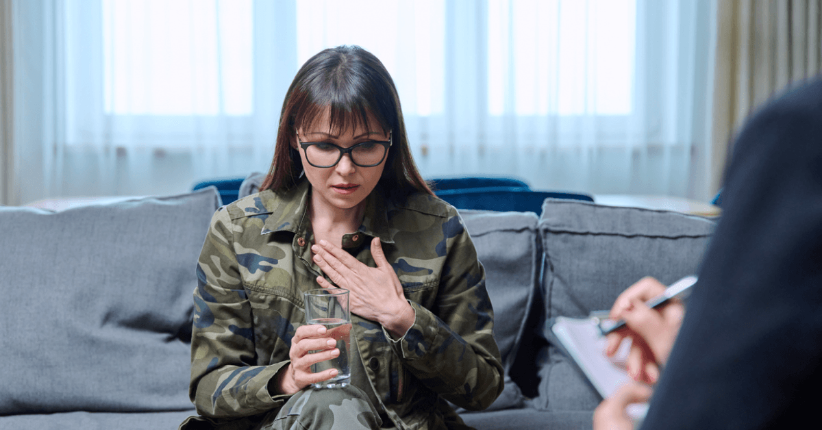 a soldier drinking a glass of water seeing a healthcare professional