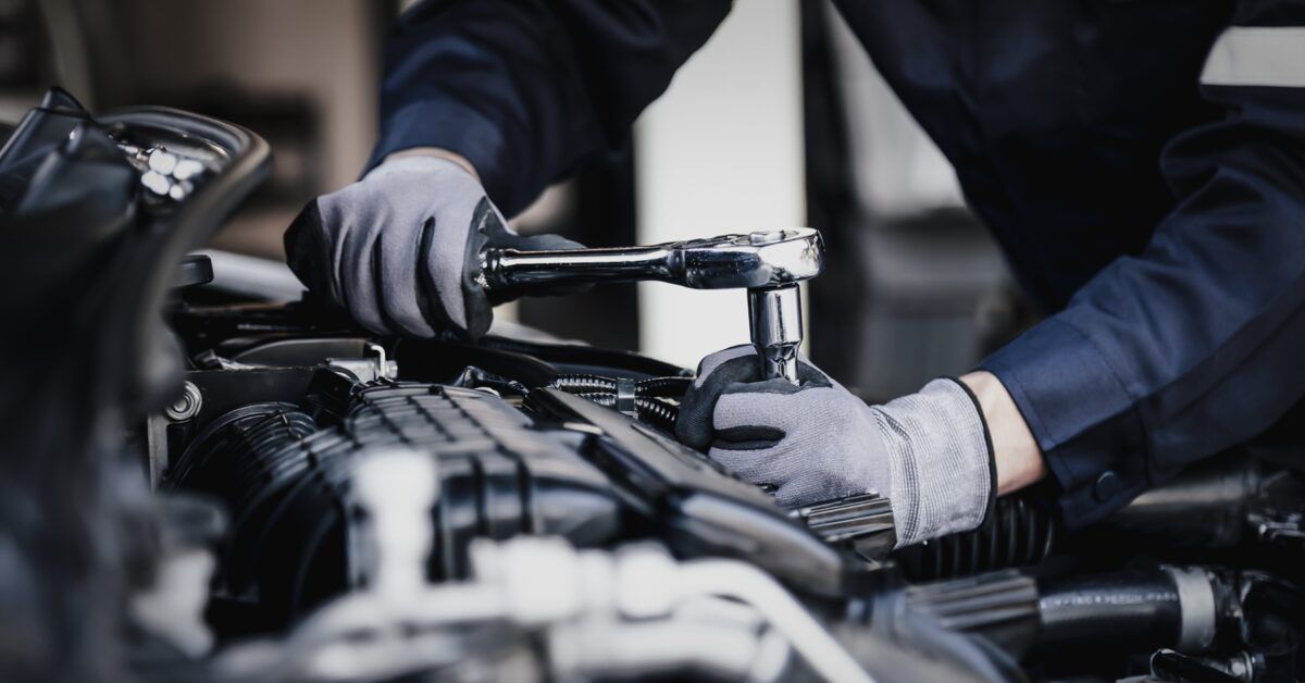 Professional mechanic working on the engine of the car in the garage