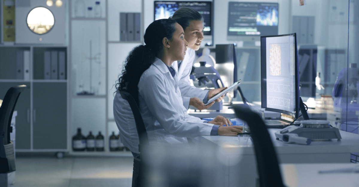 Focused, serious medical scientists analyzing research scans on a computer, working late in the laboratory.